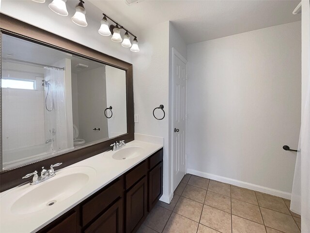 full bath with tile patterned flooring, double vanity, toilet, and a sink