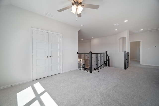 carpeted spare room featuring baseboards, visible vents, and recessed lighting