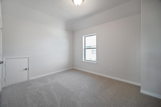 carpeted spare room featuring baseboards