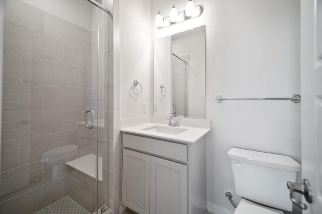 bathroom featuring a shower stall, toilet, and vanity