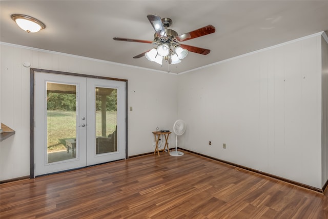 unfurnished room featuring ceiling fan, french doors, dark hardwood / wood-style floors, crown molding, and wood walls