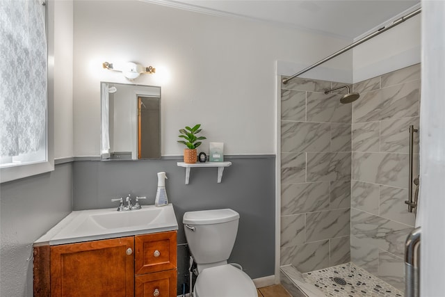 bathroom with vanity, toilet, and tiled shower