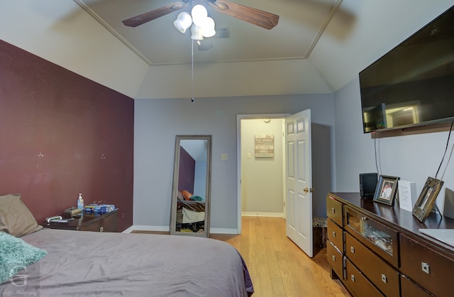 bedroom with ceiling fan, vaulted ceiling, and light hardwood / wood-style floors