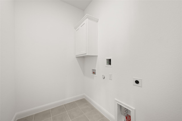 clothes washing area featuring washer hookup, cabinets, hookup for an electric dryer, hookup for a gas dryer, and light tile patterned floors