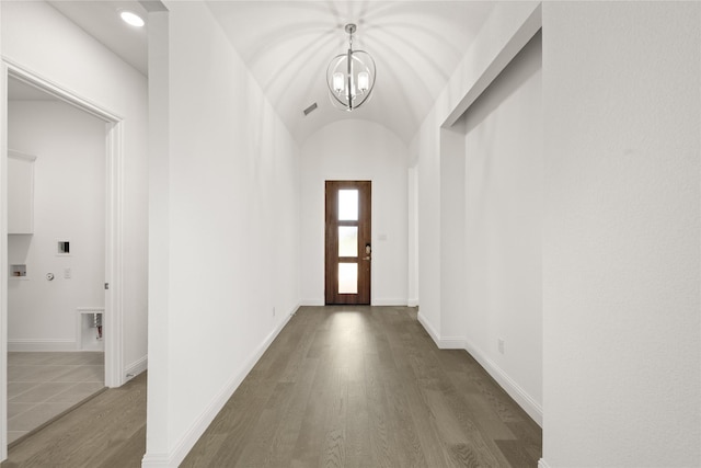 interior space featuring dark hardwood / wood-style flooring, an inviting chandelier, and lofted ceiling