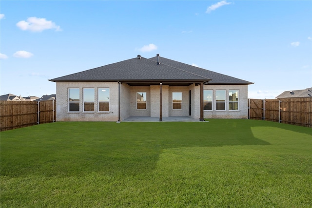 rear view of property featuring a patio and a lawn