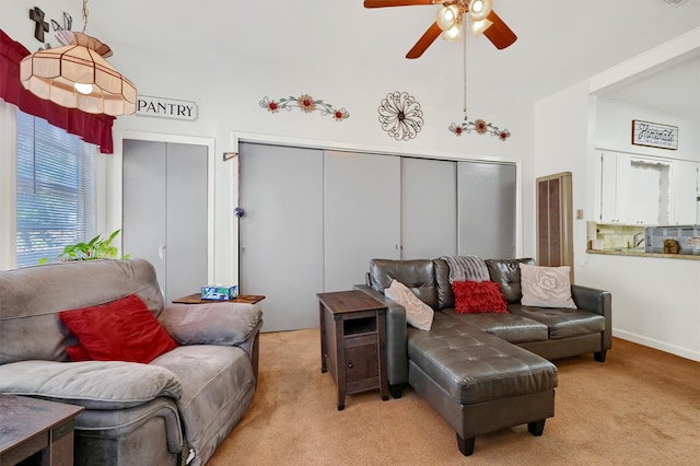 carpeted living room with ceiling fan