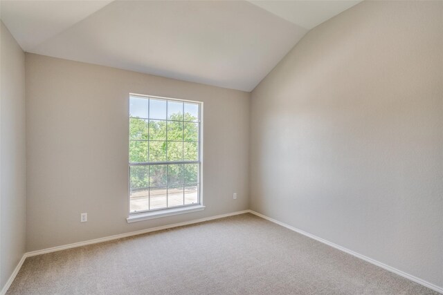 carpeted empty room with lofted ceiling