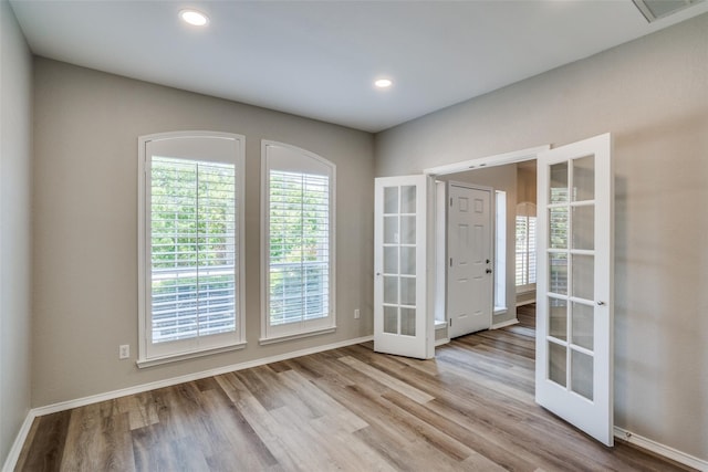 unfurnished room featuring french doors and light wood-type flooring