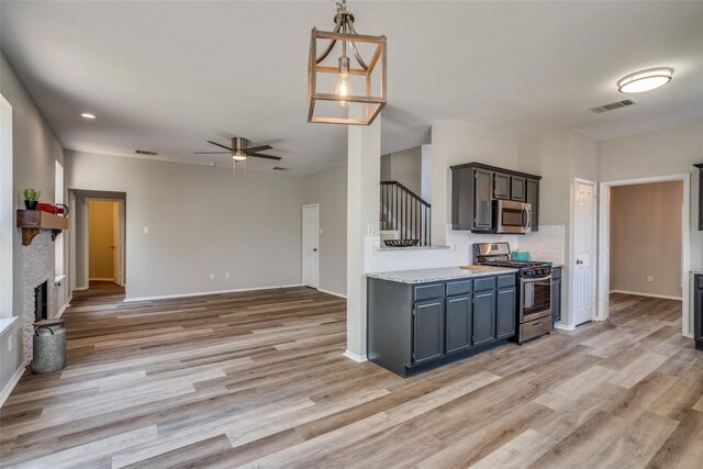 kitchen with appliances with stainless steel finishes, ceiling fan, and light hardwood / wood-style flooring