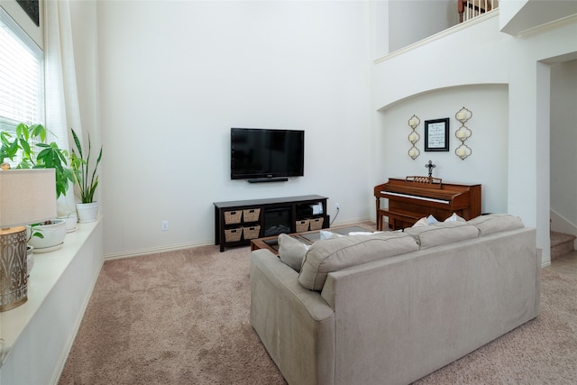 carpeted living room featuring a high ceiling