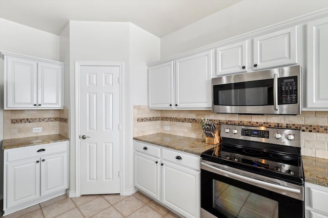 kitchen featuring tasteful backsplash, light tile patterned flooring, white cabinets, and appliances with stainless steel finishes