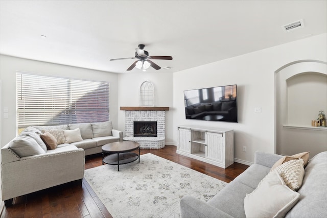 living room featuring a fireplace, dark hardwood / wood-style flooring, and ceiling fan