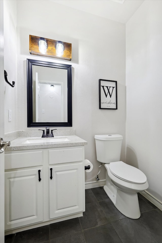 bathroom with tile patterned flooring, vanity, and toilet