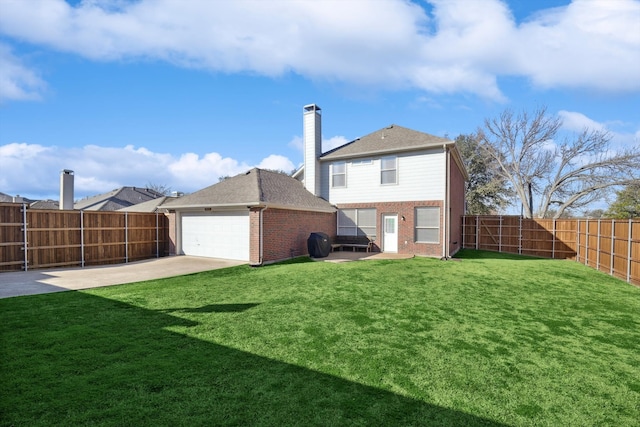 back of property with a garage and a lawn