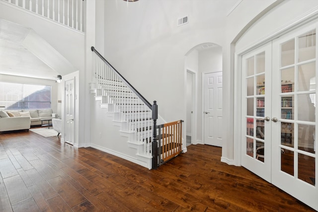 foyer entrance featuring french doors, dark hardwood / wood-style floors, and a high ceiling