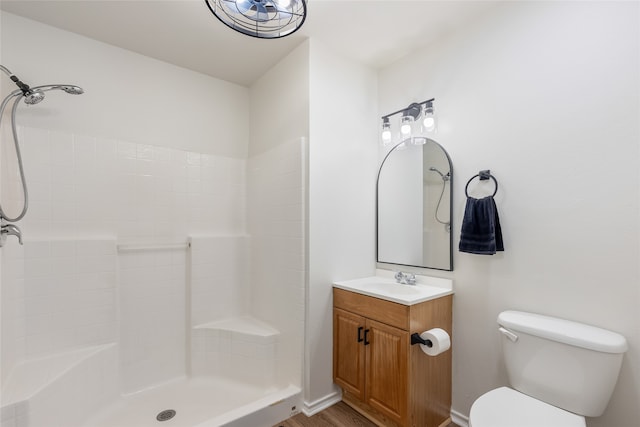 bathroom with a shower, wood-type flooring, vanity, and toilet