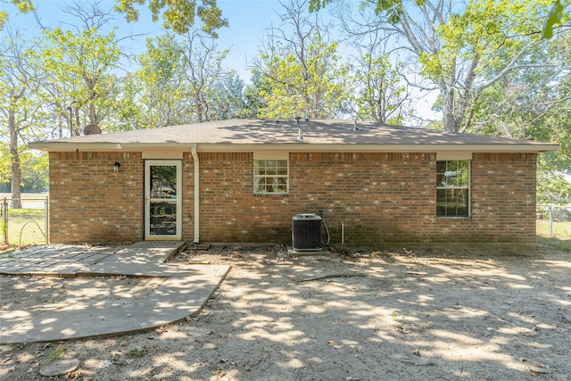 rear view of property with cooling unit and a patio