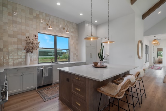 kitchen with dishwasher, sink, vaulted ceiling, decorative backsplash, and light hardwood / wood-style floors