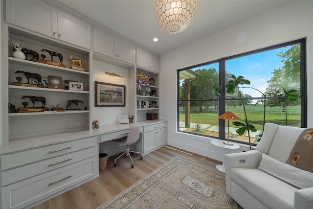 home office with built in desk and light wood-type flooring