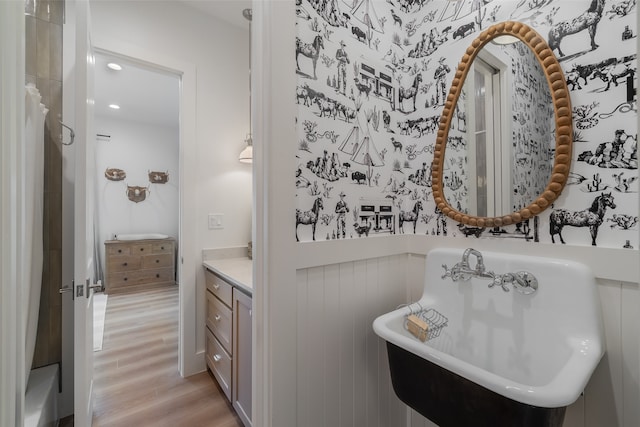 bathroom featuring a washtub, vanity, and hardwood / wood-style flooring