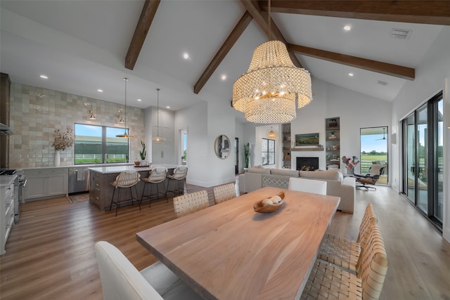 dining room featuring beamed ceiling, an inviting chandelier, high vaulted ceiling, and light hardwood / wood-style flooring