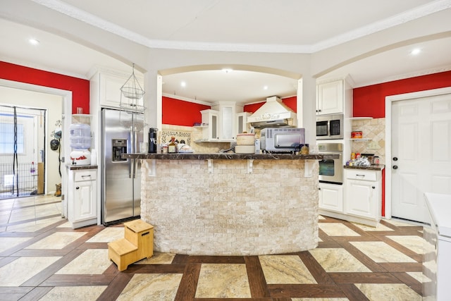 kitchen with ornamental molding, white cabinetry, stainless steel appliances, and backsplash