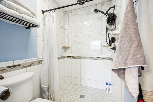 bathroom featuring toilet, curtained shower, and tile walls