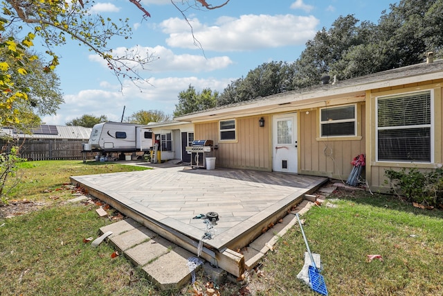 back of house featuring a wooden deck and a lawn