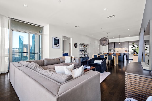 living room with expansive windows and dark hardwood / wood-style flooring