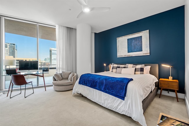 bedroom with expansive windows, light carpet, and ceiling fan