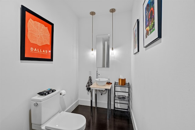 bathroom featuring wood-type flooring, sink, and toilet