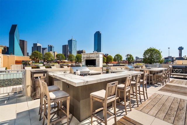 view of patio featuring an outdoor kitchen, a bar, and a grill