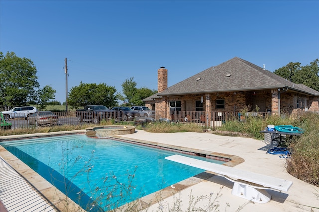 view of pool featuring an in ground hot tub, a patio, and a diving board