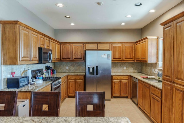 kitchen featuring light stone countertops, black appliances, sink, and light tile patterned floors