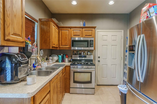 kitchen with sink, appliances with stainless steel finishes, and light tile patterned floors