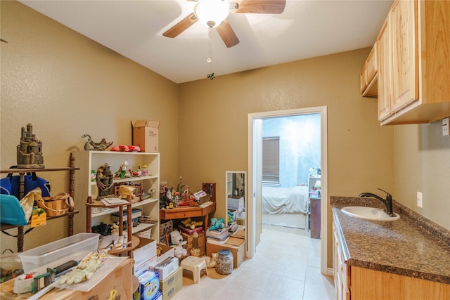 interior space with light tile patterned flooring, ceiling fan, and sink