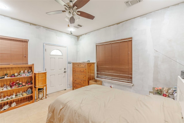 tiled bedroom featuring ceiling fan