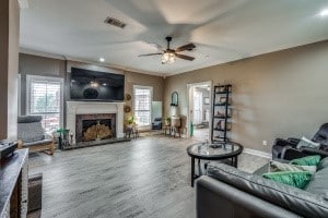 living room with ceiling fan, hardwood / wood-style flooring, and ornamental molding