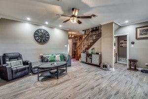 living room with crown molding, hardwood / wood-style flooring, and ceiling fan