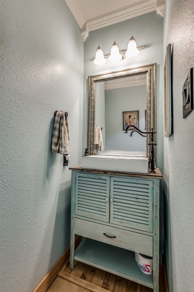 bathroom with crown molding and hardwood / wood-style flooring