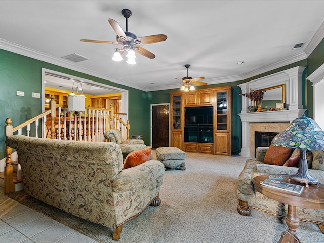 living room with crown molding, a tiled fireplace, light colored carpet, and ceiling fan