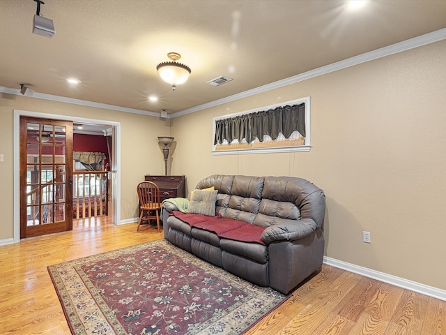 living room with light hardwood / wood-style floors and crown molding