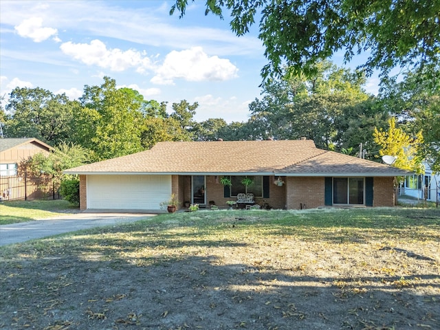 ranch-style house featuring a front lawn and a garage