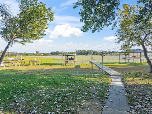 view of home's community with a rural view, a lawn, and a playground