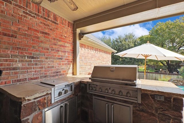 view of patio / terrace featuring ceiling fan, a grill, and exterior kitchen