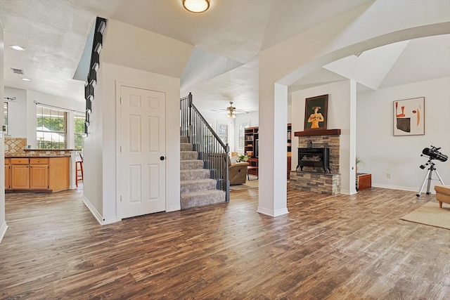 unfurnished living room with ceiling fan, lofted ceiling, a fireplace, and dark hardwood / wood-style floors