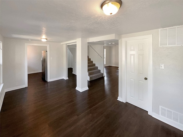 unfurnished room featuring dark hardwood / wood-style floors and a textured ceiling