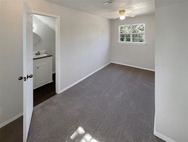 carpeted spare room with ceiling fan and sink