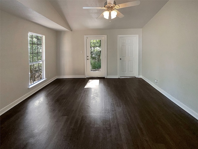 empty room with lofted ceiling, ceiling fan, and dark wood-type flooring